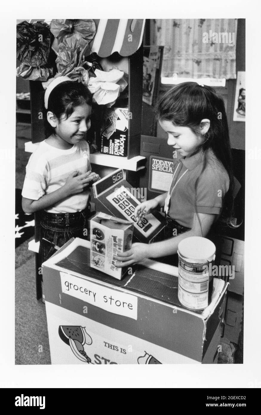 Austin Texas USA, vers 1991: Les filles de la maternelle 'épicerie' prétendent faire des achats et d'enregistrer des achats car ils apprennent sur les enfants jouent à l'épicerie et apprennent sur l'argent et les affaires. ©Bob Daemmrich Banque D'Images