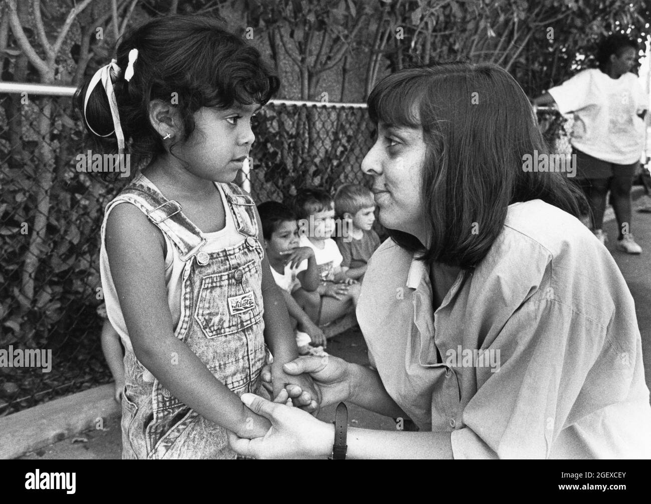 Austin Texas USA, vers 1999: Une enseignante interagissant avec une jeune fille d'avant-école sur le terrain de jeu dans un centre de garderie privé. ©Bob Daemmrich Banque D'Images Austin Texas USA, vers 1999: Une enseignante interagissant avec une jeune fille d'avant-école sur le terrain de jeu dans un centre de garderie privé. ©Bob Daemmrich Banque D'Images