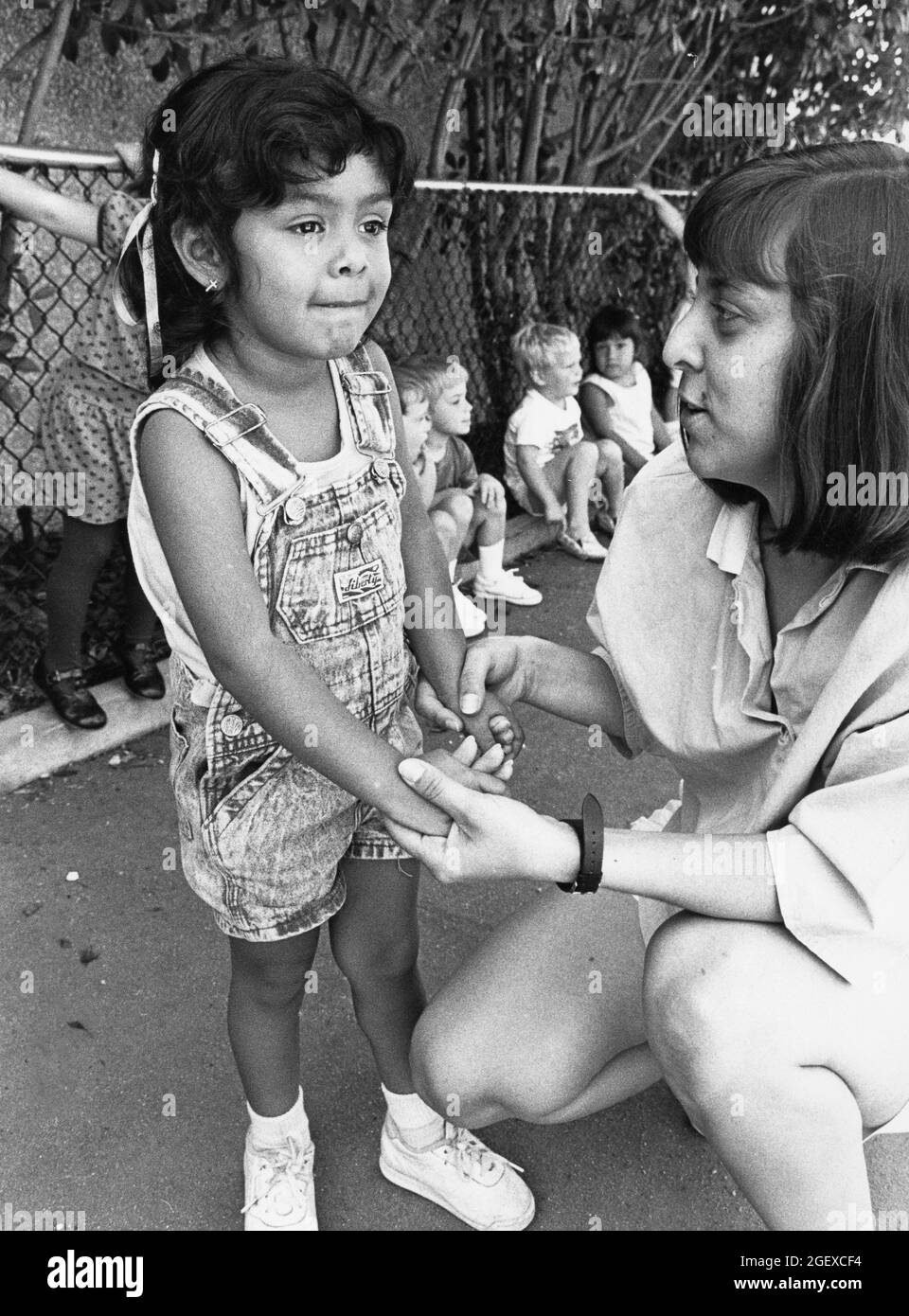 Austin Texas USA, vers 1999: Une enseignante interagissant avec une jeune fille d'avant-école sur le terrain de jeu dans un centre de garderie privé. ©Bob Daemmrich Banque D'Images Austin Texas USA, vers 1999: Une enseignante interagissant avec une jeune fille d'avant-école sur le terrain de jeu dans un centre de garderie privé. ©Bob Daemmrich Banque D'Images