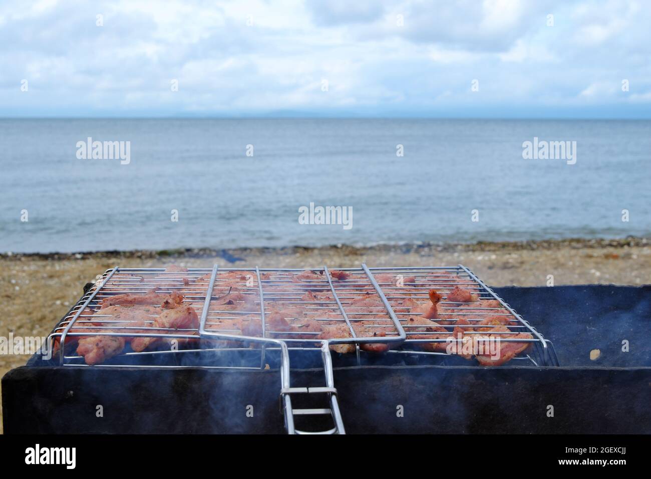 Barbecue sur la plage. La viande marinée est frite sur des coals chauds, trempés dans de la fumée parfumée. Mise au point sélective. Banque D'Images