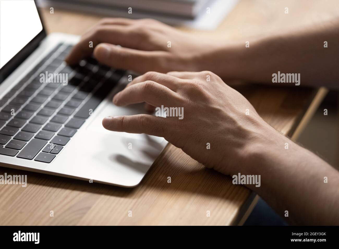 Gros plan homme dactylographiant les mains sur un ordinateur portable moderne au bureau Banque D'Images
