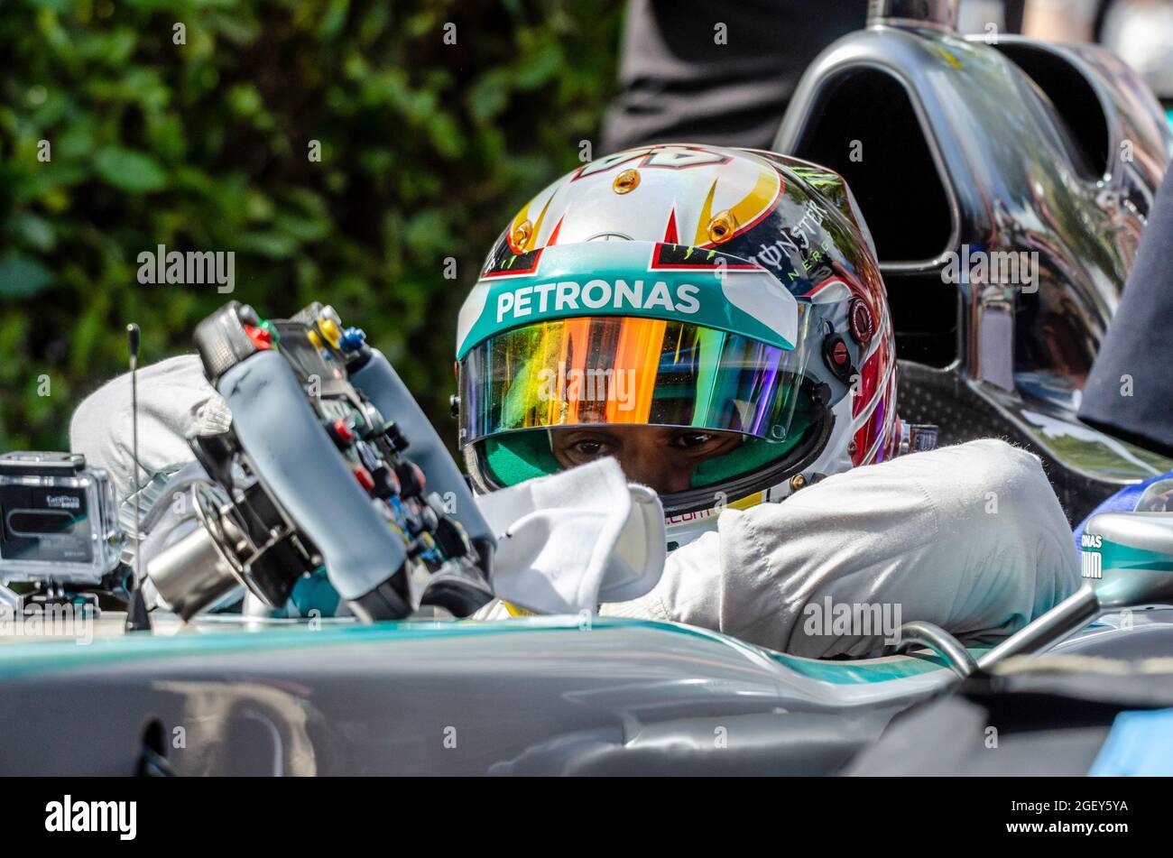 Lewis Hamilton, pilote de course Mercedes Formule 1 Grand Prix s'abaissant dans le cockpit de la voiture Petronas Mercedes F1 dans la zone de la fosse de Goodwood Banque D'Images