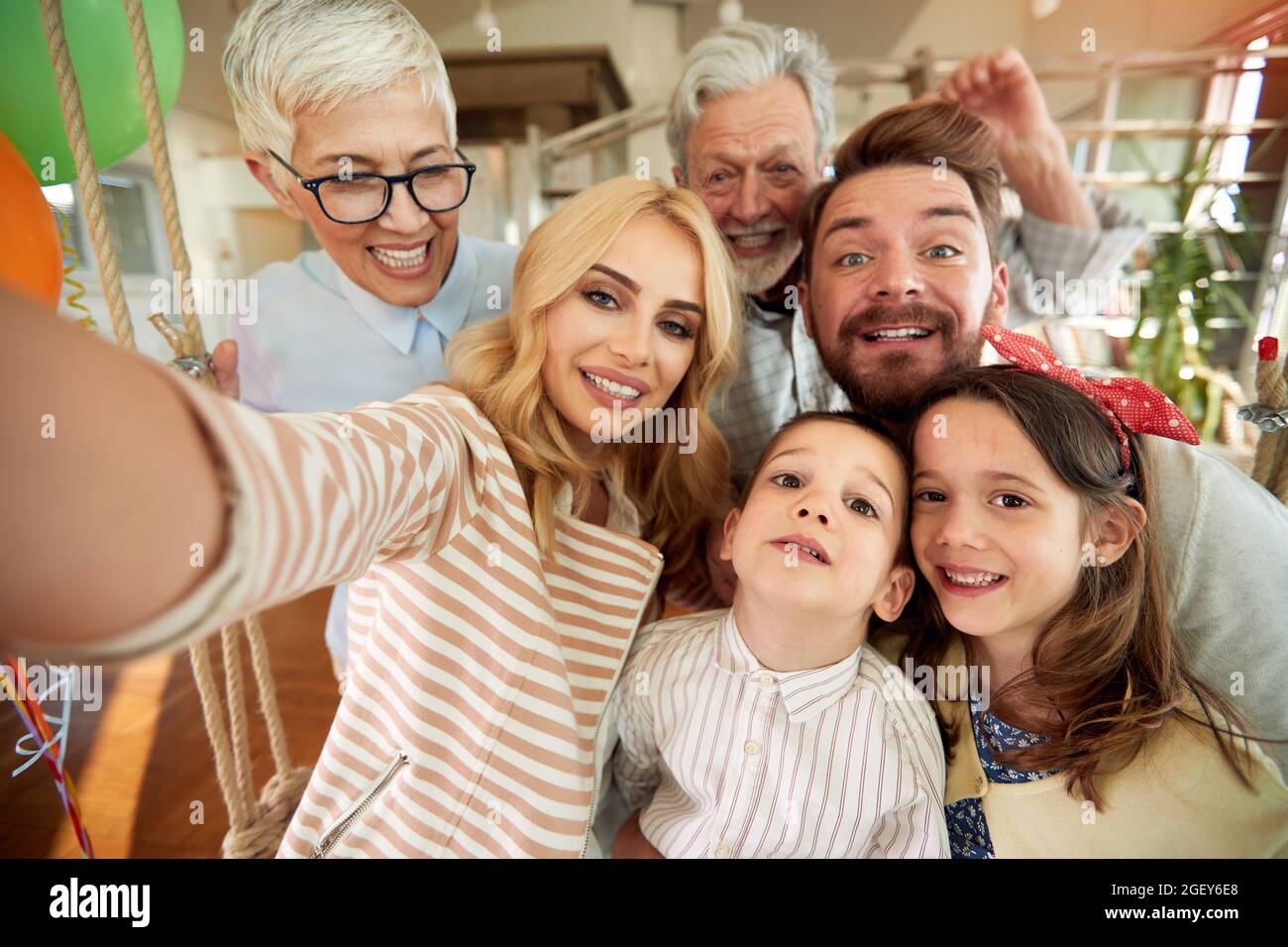 Famille de trois générations ayant un bon moment tout en prenant un selfie dans une atmosphère gaie à la maison ensemble. Famille, loisirs, ensemble Banque D'Images