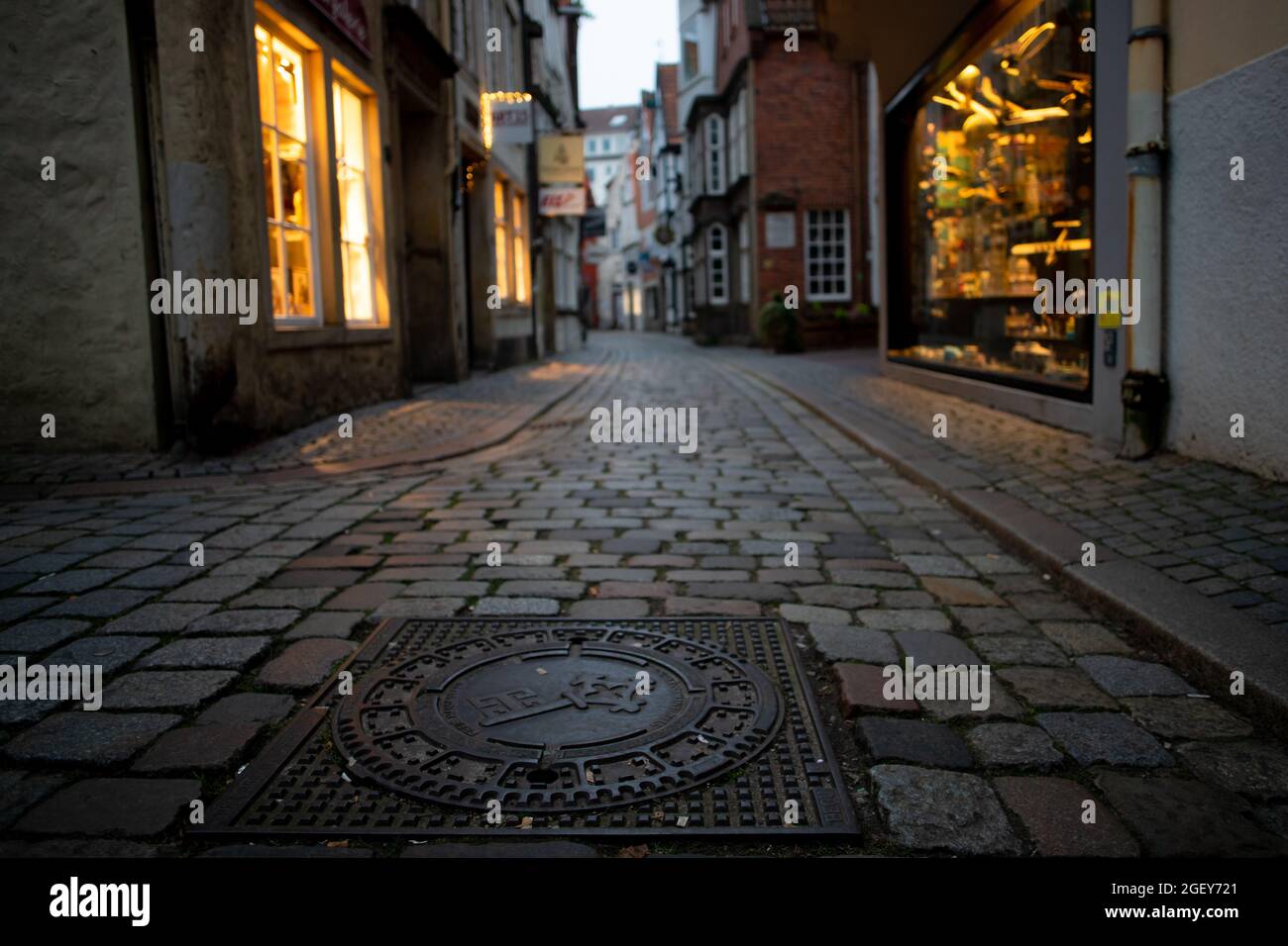 Petite rue avec beau pavé et bâtiments anciens dans la célèbre zone piétonne touristique 'Schnoor' à Brême, Allemagne dans la soirée Banque D'Images