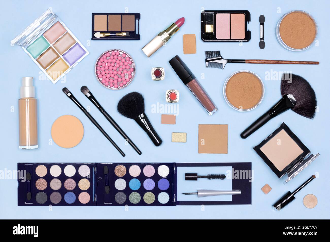 Maquillage plat. Divers produits de maquillage et accessoires sur table bleue, vue du dessus Banque D'Images