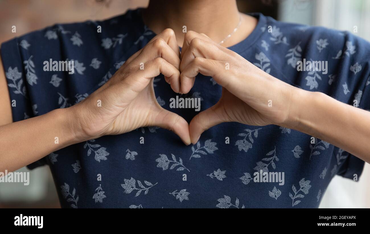 Femme de race mixte reconnaissante montrant le doigt en forme de coeur geste Banque D'Images