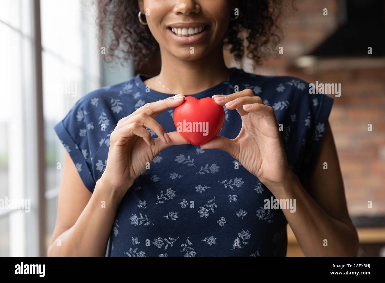 Bonne fille volontaire afro-américaine tenant le cœur rouge Banque D'Images