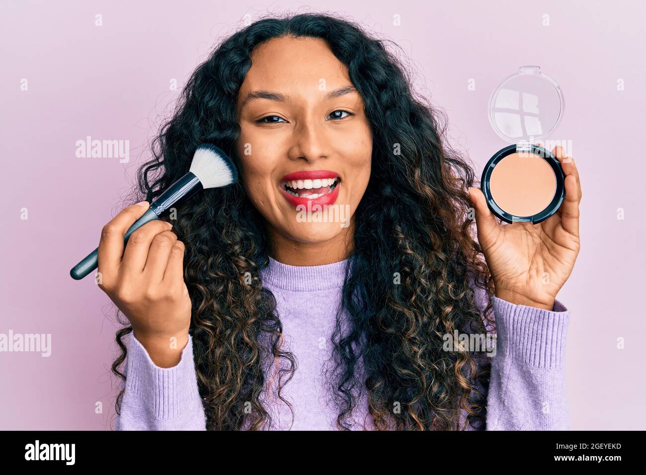 Jeune femme latine tenant la brosse à maquillage et rougir sourire et rire  fort parce que drôle fou blague Photo Stock - Alamy
