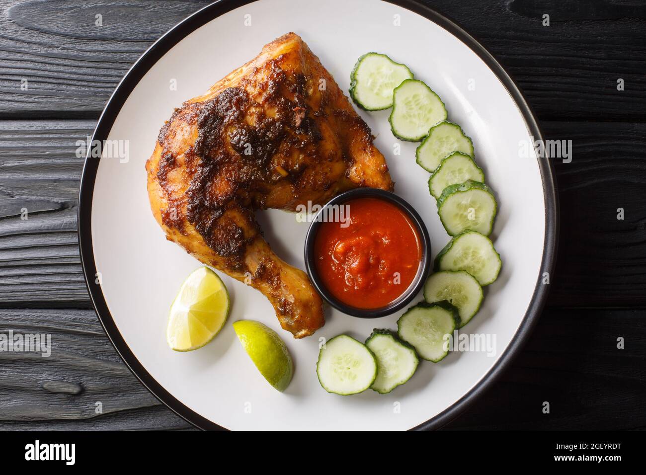 Ayam Bakar poulet grillé indonésien dans l'assiette sur la table. Vue horizontale du dessus Banque D'Images