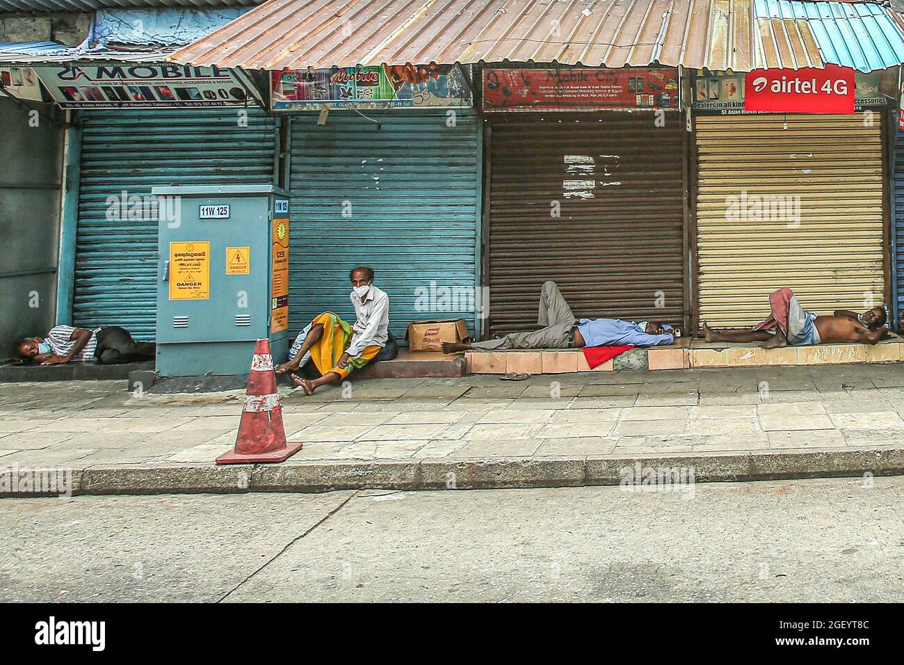 Des hommes sans-abri se réfugient devant les boutiques fermées de Colombo, au Sri Lanka, lors d'un confinement à l'échelle du pays en raison de la propagation de Covid-19 le dimanche 22 août 2021. (Photo de Saman Abesiriwardana/Pacific Press/Sipa USA) Banque D'Images