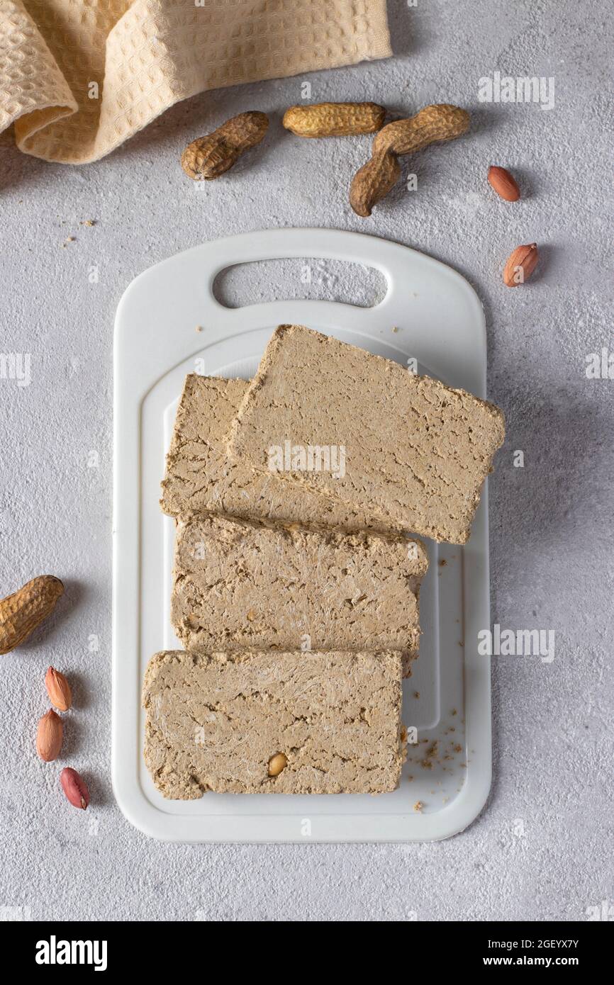 Halva de tournesol douce avec arachide sur tableau blanc sur fond gris clair. Banque D'Images