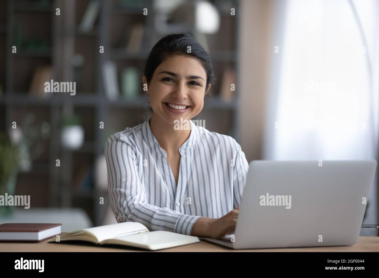 Portrait d'une femme indienne souriante travaillant sur un ordinateur portable Banque D'Images