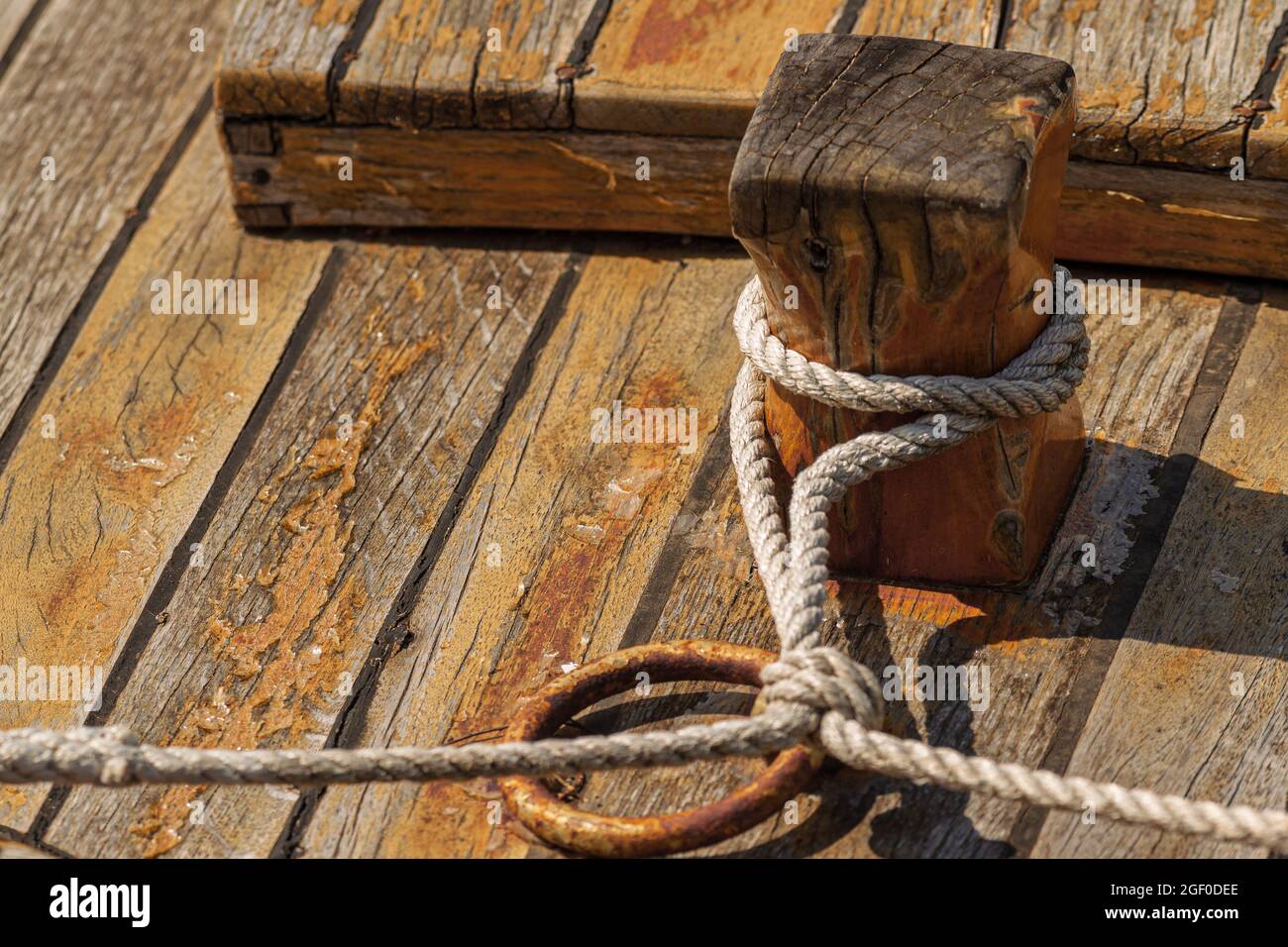 Un gros plan d'une corde enroulé d'un pilier en bois sur une surface en bois Banque D'Images