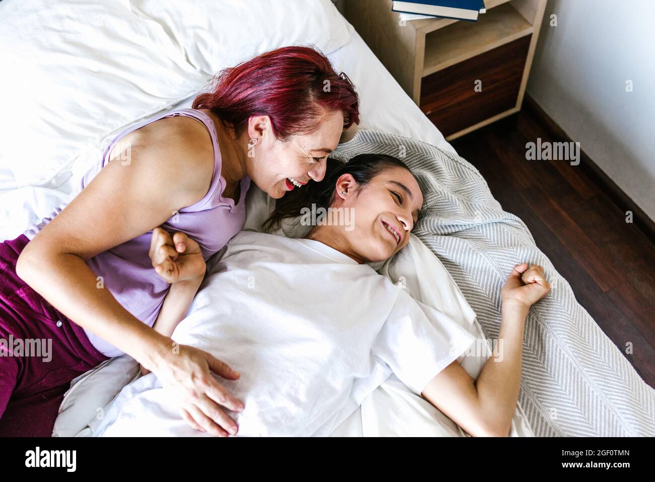 Jeune fille hispanique avec paralysie cérébrale couché au lit avec sa mère  souriante, dans le concept de handicap en Amérique latine Photo Stock -  Alamy
