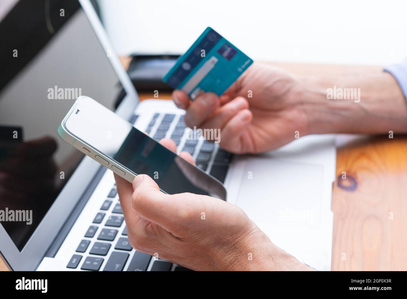Homme shopping et payer avec téléphone cellulaire et ordinateur portable et carte de crédit. Copier l'espace. Banque D'Images