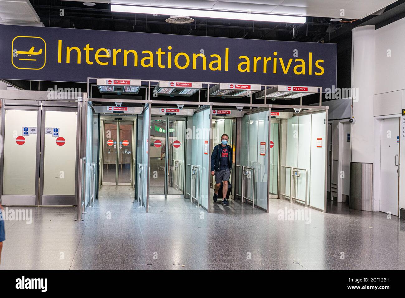 GATWICK, LONDRES, ROYAUME-UNI. 22 août 2021. Les passagers portant un masque arrivent au terminal international du Nord à l'aéroport de Gatwick. Le gouvernement a récemment renoncé à la quarantaine pour les passagers entièrement vaccinés arrivant des pays de la liste ambre. Credit amer ghazzal/Alamy Live News Banque D'Images