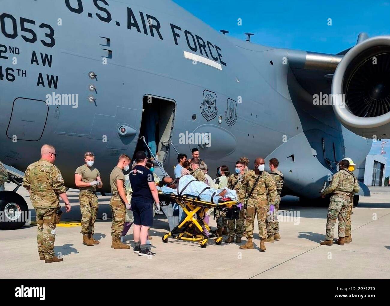 Base aérienne d'Al Udeied, Qatar. 21 août 2021. Les aviateurs de l'US Air Force déchargent un réfugié afghan qui a donné naissance à un bébé à bord de l'avion C-17 Globemaster III lors de l'évacuation de Kaboul le 21 août 2021 à la base aérienne d'Al Udeied, au Qatar. Credit: Planetpix/Alamy Live News Banque D'Images
