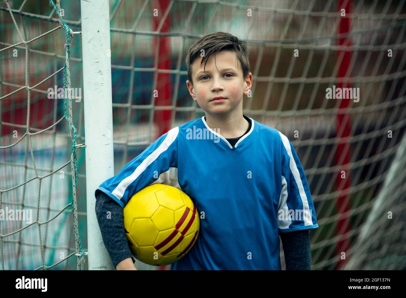 Jeune garçon près de la porte sur le terrain de football. Banque D'Images