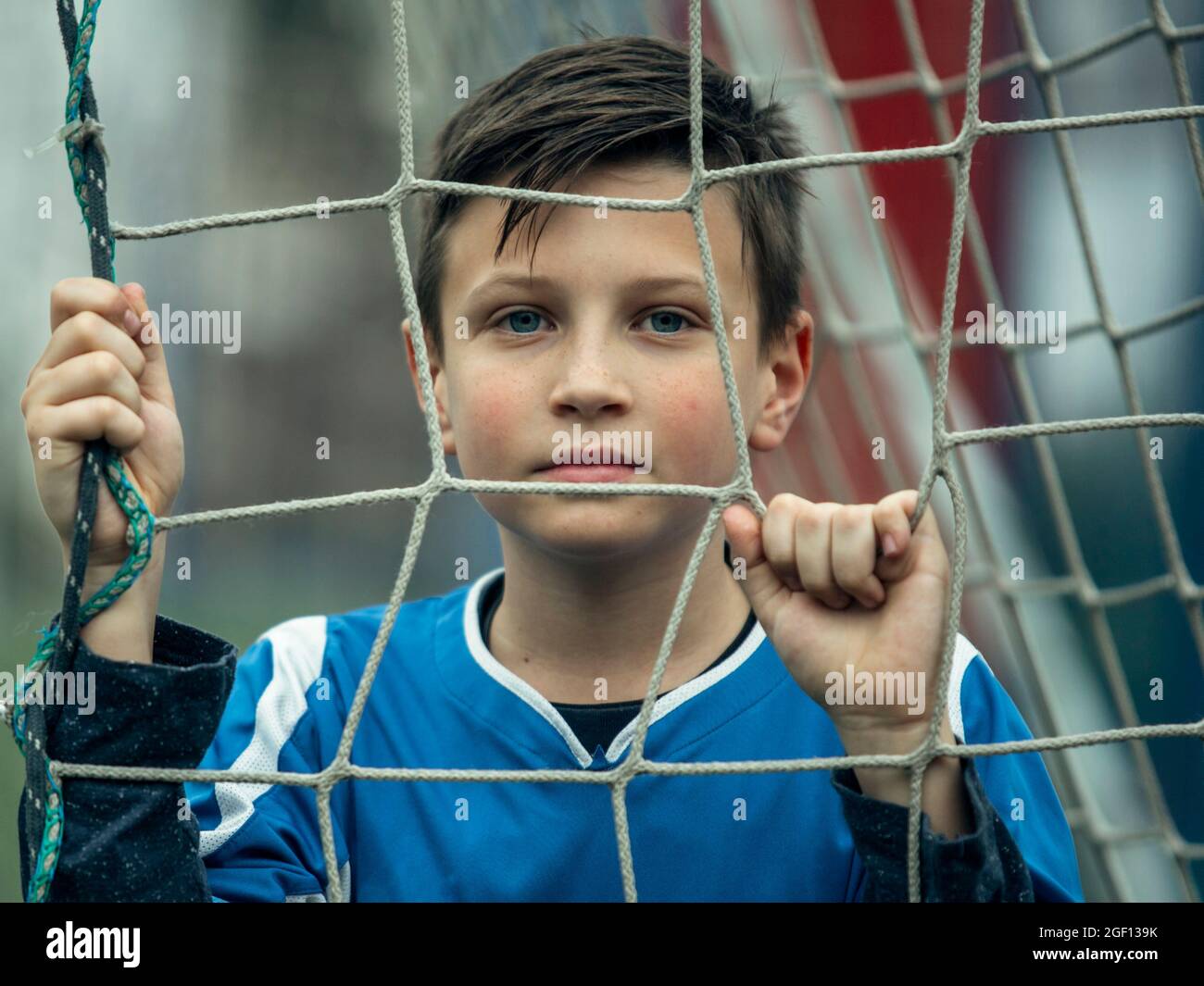 Un portrait de jeune garçon près de la porte sur le terrain de football. Banque D'Images