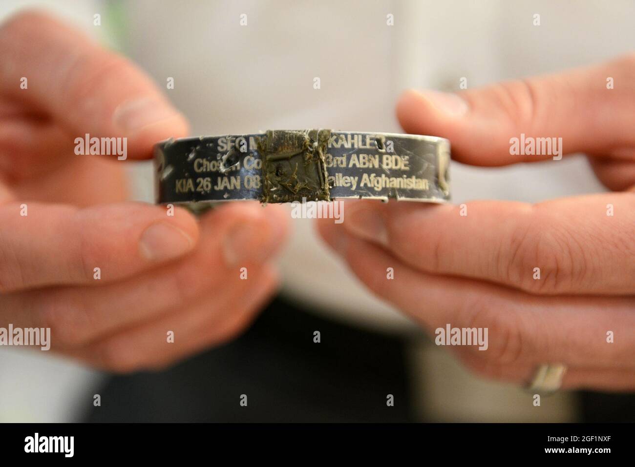 Sgt. Ryan Pitts tient un bracelet qu'il porte qui commémore le regretté Sgt. Matthew Kahler, ancien sergeant de peloton de 2e peloton, qui est collé sur un autre bracelet (non visible) qui commémore les morts du 1er peloton, Compagnie choisie, qui ont été tués le 9 novembre 2007, dans une embuscade. Commémoré sur le deuxième bracelet sont: Capitaine Matthew Ferrara, SPC. Joseph Lantour, Cpl. Lester Roque, Cpl. Sean Langevin et Sgt. Jeffrey Mersman. Ce bracelet empêche l'éclat de l'obus sur le poignet des Pitts. Banque D'Images