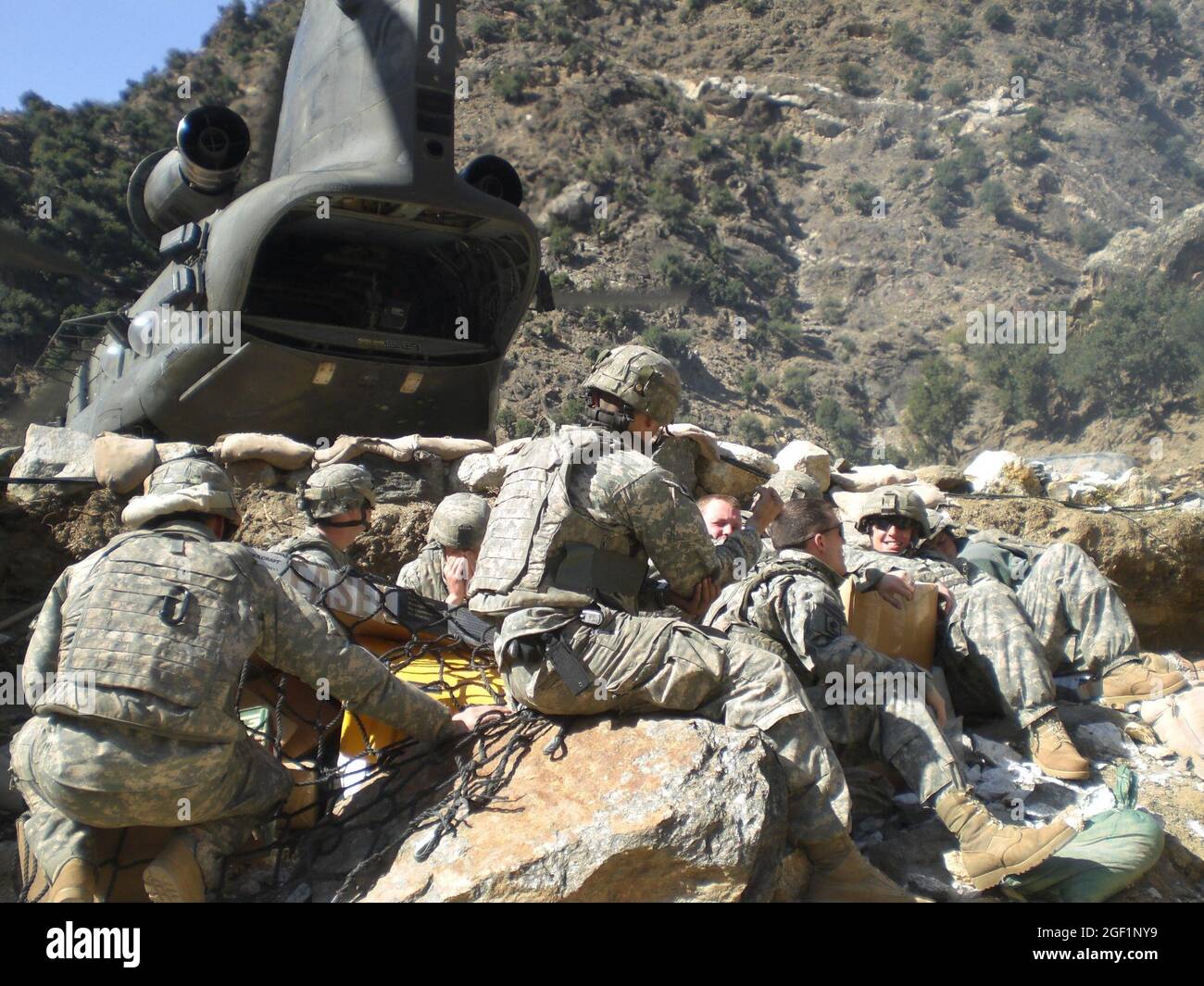 Les membres du 2e peloton, Chosen Company, déballent les fournitures apportées par hélicoptère à combat Outpost Bella, en Afghanistan, au printemps 2008. COP Bella était inaccessible par véhicule, ce qui garantit que toutes les fournitures et tous les renforts soient transportés par air. Banque D'Images