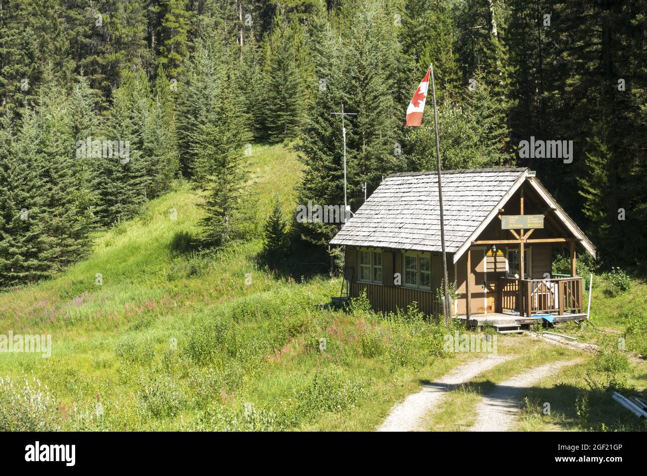Parc national Banff Bureau de contrôle des avalanches extérieur de la cabine en bois avec drapeau canadien à Mount Norquay Alpine Meadow et Green Forest dans les Rocheuses canadiennes Banque D'Images