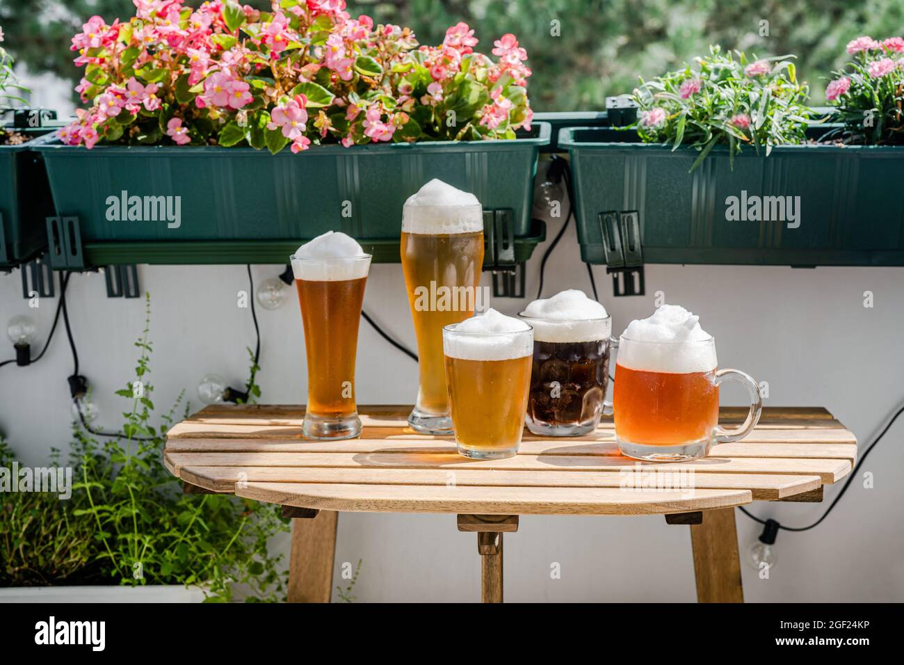 Verres à bière sur une table en bois sur un balcon vert Banque D'Images
