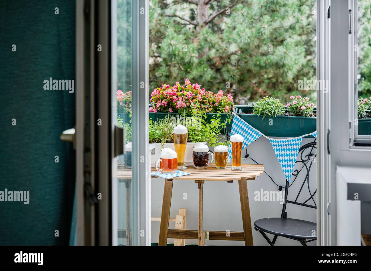 Table en bois avec verres à bière sur le balcon vert Banque D'Images