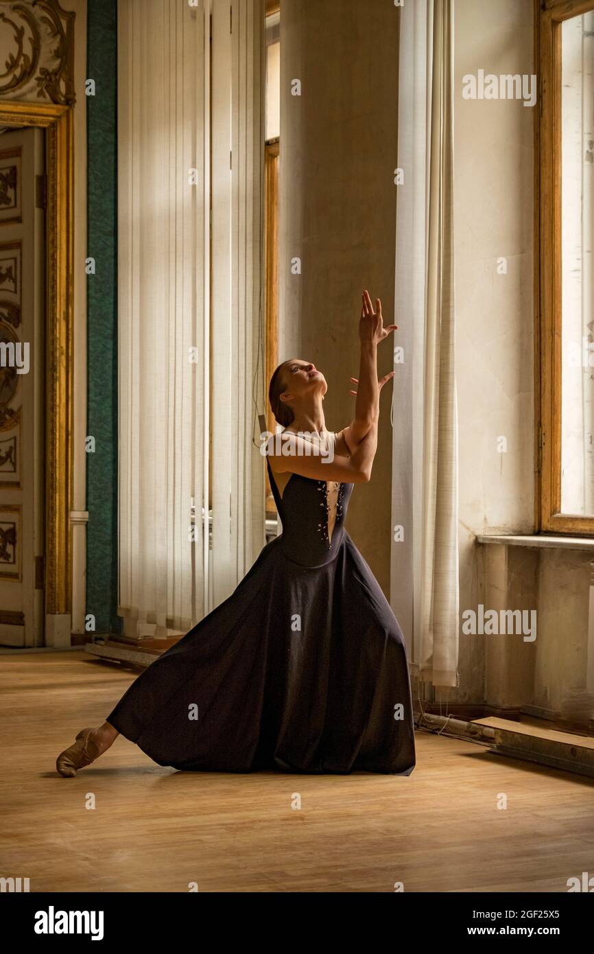 Ballerine solo danse dans les salles d'un ancien palais russe habillé d'une robe élaborée Banque D'Images