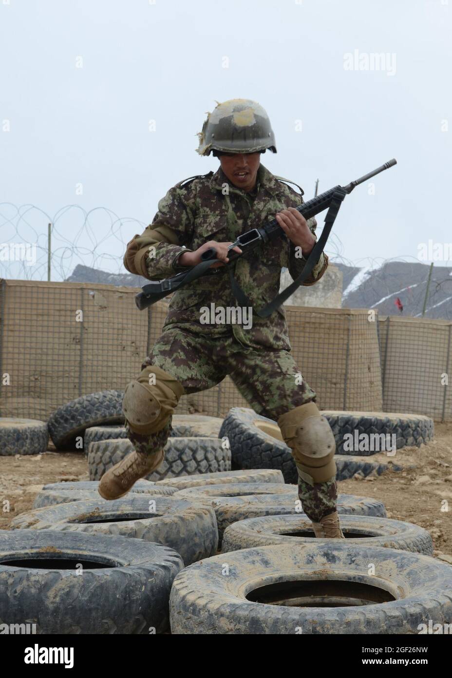 Province de PAKTYA, Afghanistan – un stagiaire de base de l’Armée nationale afghane passe des pneus lors d’un cours d’obstacles au Centre régional d’instruction militaire de Gardez, le 25 février 2013. Le cours de formation de base de neuf semaines permettra de terminer environ 600 futurs soldats de l'ANA. (É.-U. Photo de l'armée par la SPC. Tianna Waite, 115e Détachement mobile des affaires publiques) Banque D'Images