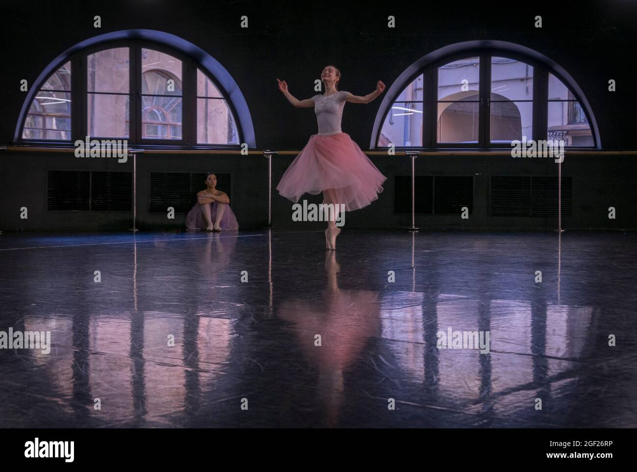 Deux ballerines pratiquent leur routine dans une salle de répétition à Saint-Pétersbourg avec un danseur observant l'autre. Banque D'Images