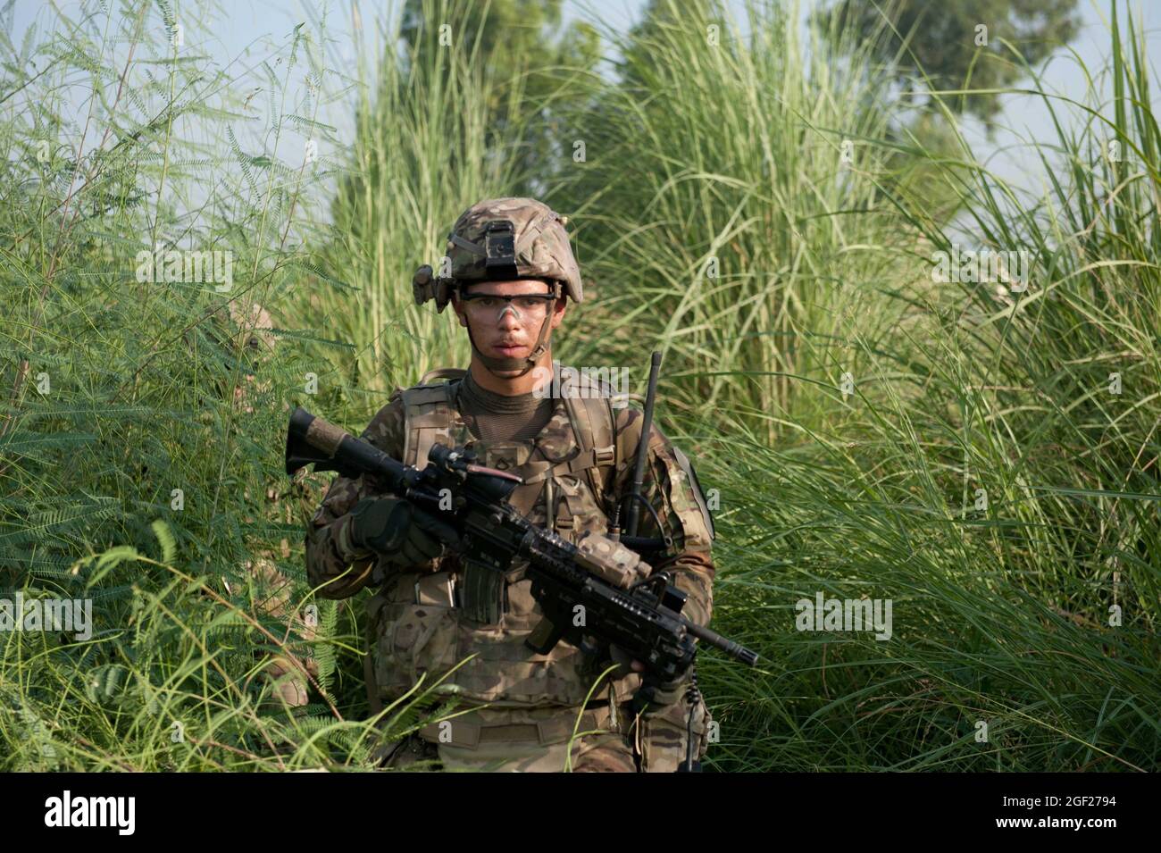 PFC de l'armée américaine. Derek Southerland, opérateur d'émetteur radio affecté à la troupe Bravo, 4e Escadron, 9e Régiment de cavalerie, 2e équipe de combat de brigade blindée, 1re Division de cavalerie, traverse un terrain surcultivé lors d'une patrouille de présence autour de la base opérationnelle Forward Fenty, dans la province de Nangarhar, en Afghanistan, le 22 août 2013. Le but de la patrouille en début de matinée était de vérifier la sécurité du périmètre de Fenty et d'engager la population locale. (É.-U. Photo de la Garde nationale de l'armée par le Sgt. Margaret Taylor/sortie) Banque D'Images PFC de l'armée américaine. Derek Southerland, opérateur d'émetteur radio affecté à la troupe Bravo, 4e Escadron, 9e Régiment de cavalerie, 2e équipe de combat de brigade blindée, 1re Division de cavalerie, traverse un terrain surcultivé lors d'une patrouille de présence autour de la base opérationnelle Forward Fenty, dans la province de Nangarhar, en Afghanistan, le 22 août 2013. Le but de la patrouille en début de matinée était de vérifier la sécurité du périmètre de Fenty et d'engager la population locale. (É.-U. Photo de la Garde nationale de l'armée par le Sgt. Margaret Taylor/sortie) Banque D'Images