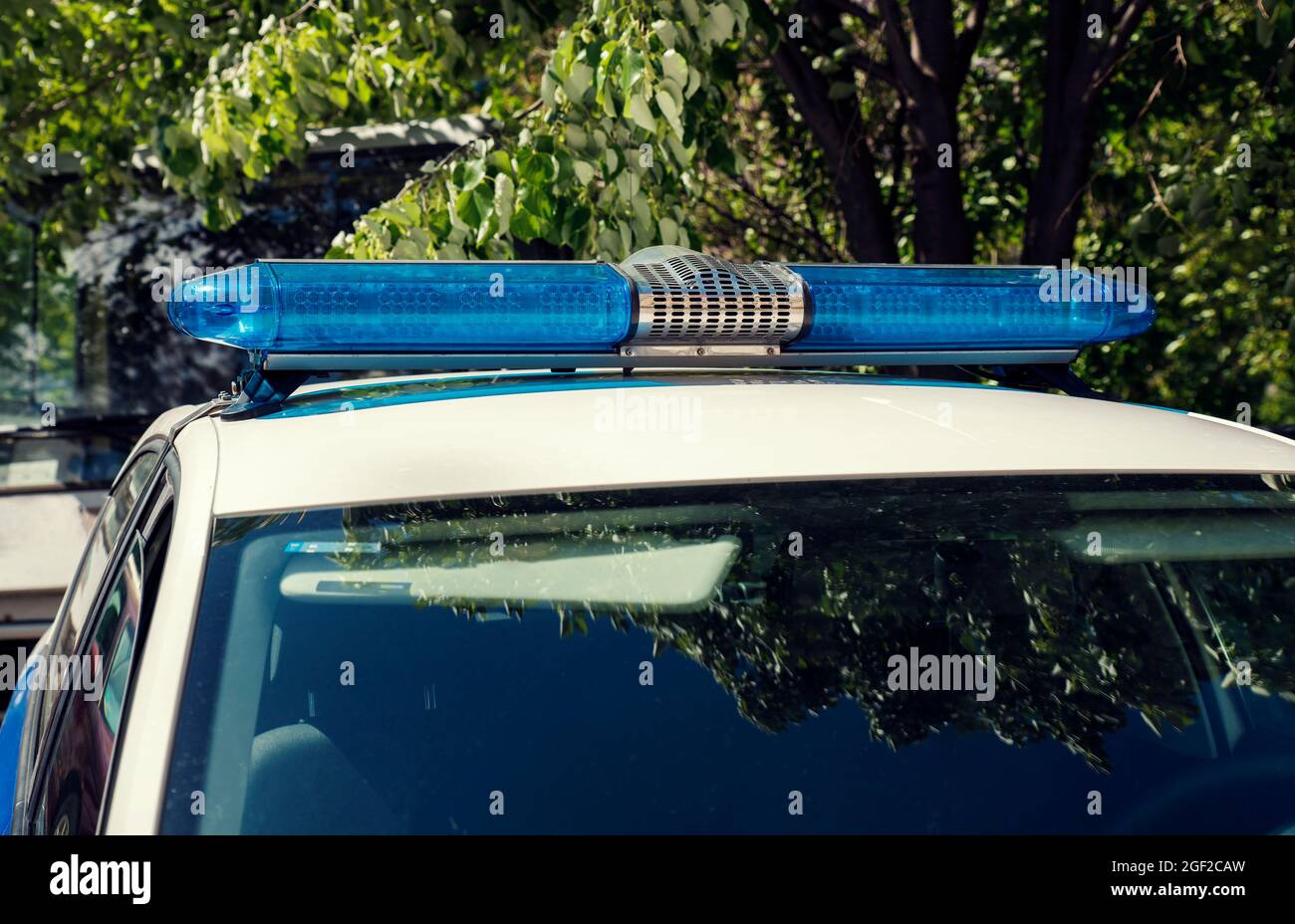 Une lumière bleue au-dessus d'une voiture de police lors d'une journée ensoleillée en été. Personne Banque D'Images