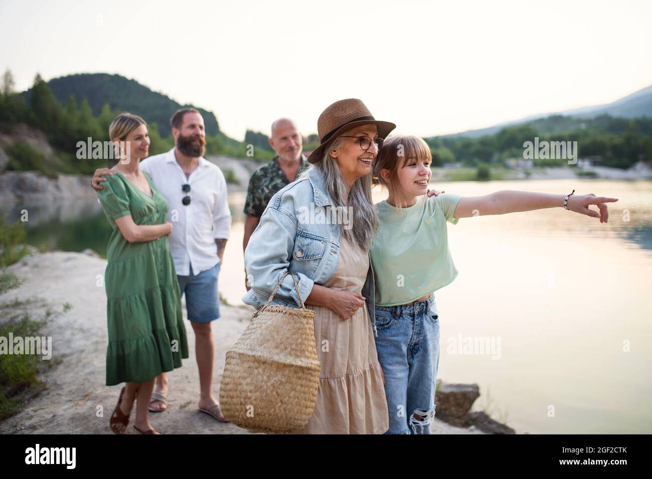 Bonne famille multigénération pendant les vacances d'été, à pied au bord du lac. Banque D'Images