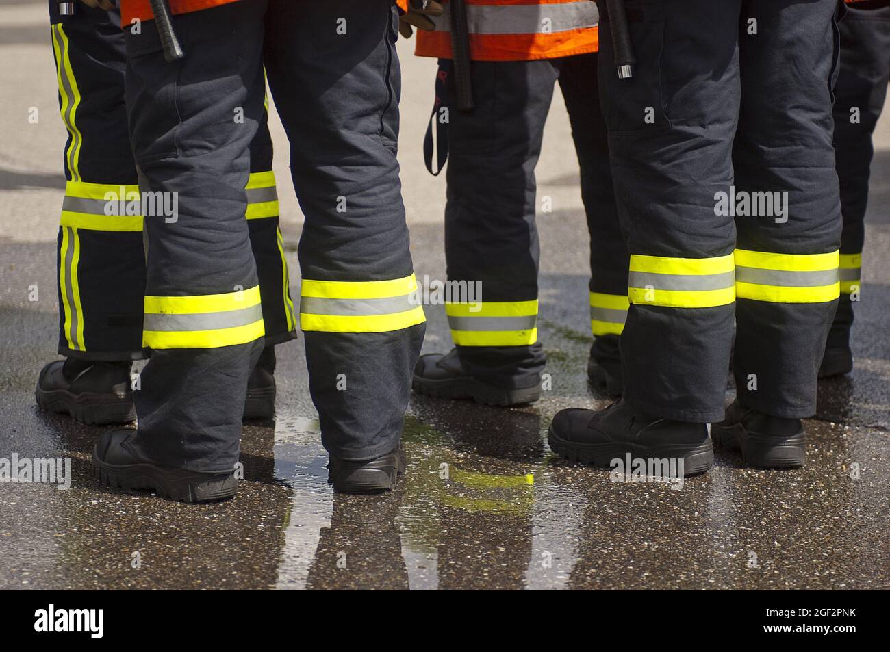 Pompiers debout ensemble, bandes rétroréfléchissantes et peinture jaune fluorescent sur leurs jambes de pantalon , Allemagne Banque D'Images