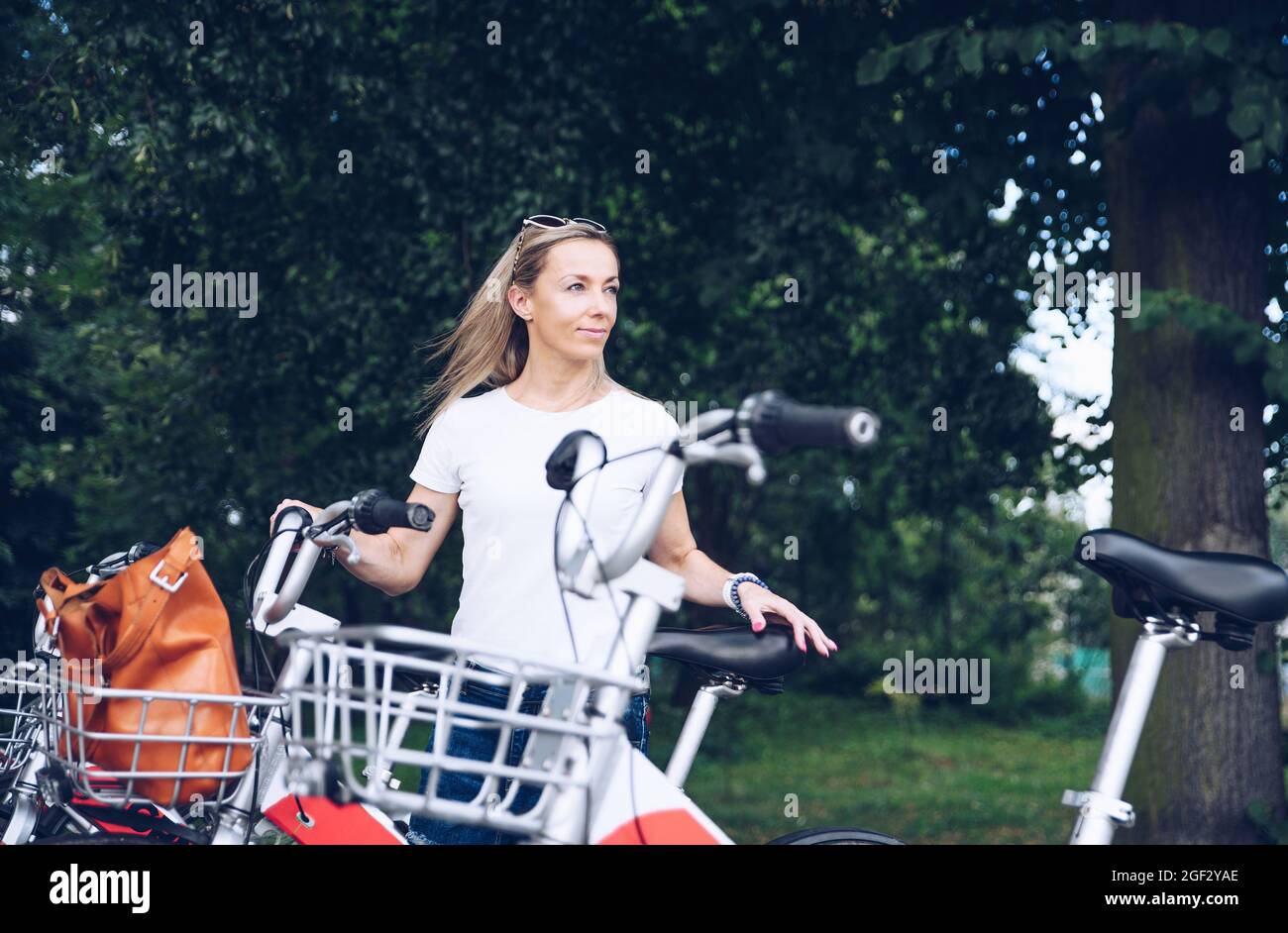Femme blonde souriante prête à louer un vélo. Location de vélos. Banque D'Images
