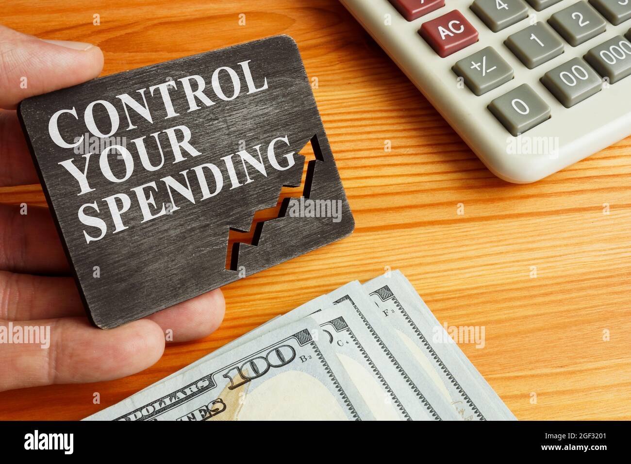 La main tient la plaque avec le contrôle vos conseils de dépenses. Banque D'Images