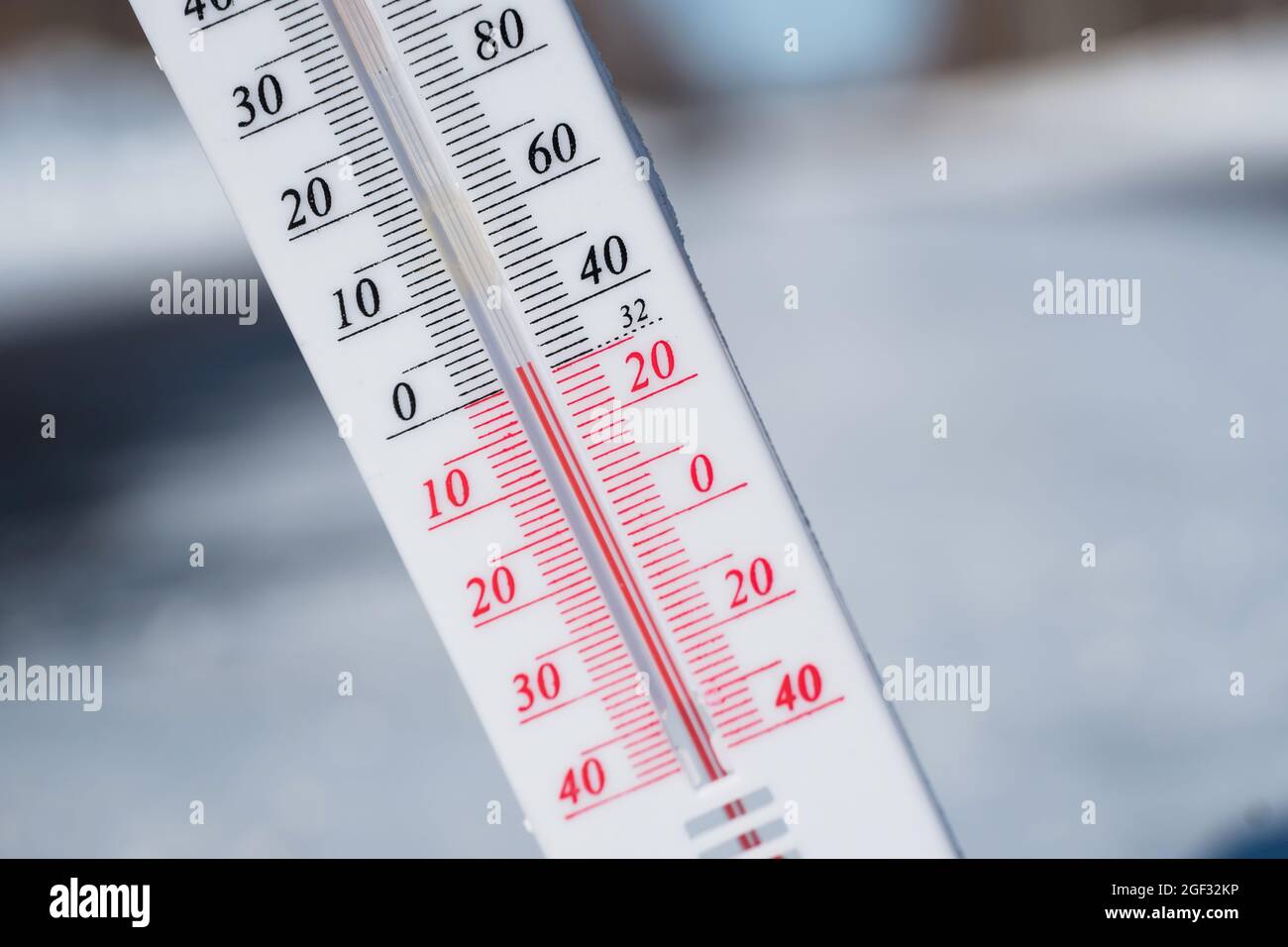 En hiver ou au printemps, le thermomètre repose sur la neige Et indique une température négative par temps froid. Conditions météorologiques avec faible débit d'air et ambie Banque D'Images
