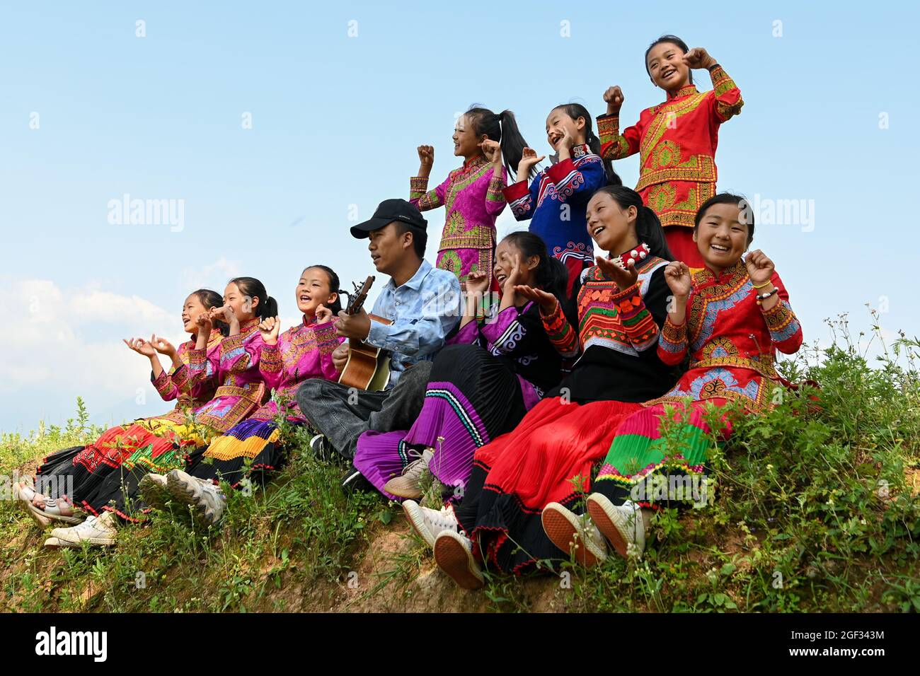 Chengdu, province chinoise du Sichuan. 6 août 2021. Les filles et leur professeur chantent en plein air à la ville de Dacao, dans le comté de Puge, préfecture autonome de Liangshan Yi, dans la province du Sichuan, dans le sud-ouest de la Chine, le 6 août 2021. Le choeur de filles de l'école primaire centrale de Dacao dans le comté de Puge a attiré l'attention après que les vidéos de leurs performances sont partagées sur de courtes plates-formes vidéo. Le chœur a été invité à assister à un festival de musique à Beijing, capitale de la Chine cet été. Credit: Tang Wenhao/Xinhua/Alay Live News Banque D'Images