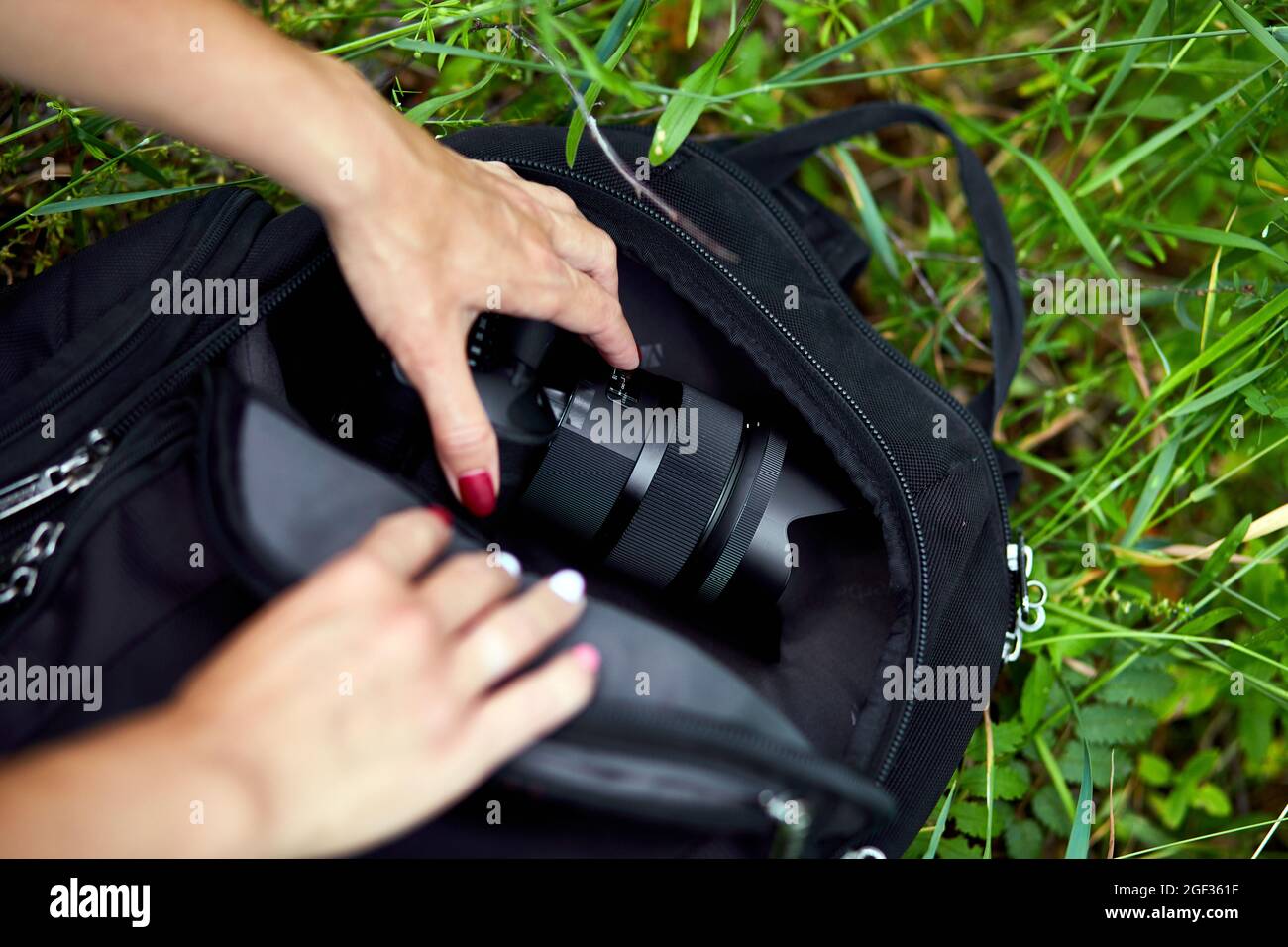 Photographe femme empoche ou sort son sac à dos d'appareil photo, sac  appareils pour la photographie vue de dessus, extérieur Photo Stock - Alamy