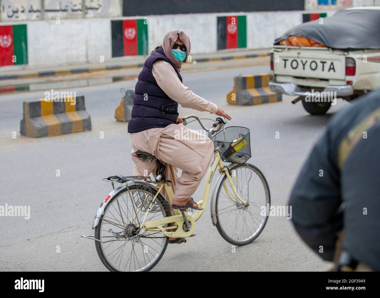 Un afghan conduit son vélo tout en portant un masque facial pour se protéger contre le COVID-19 dans les rues de Kaboul, en Afghanistan, le 29 avril 2020. (É.-U. Photo de la réserve de l'armée par la SPC. Jeffery J. Harris/publié) Banque D'Images