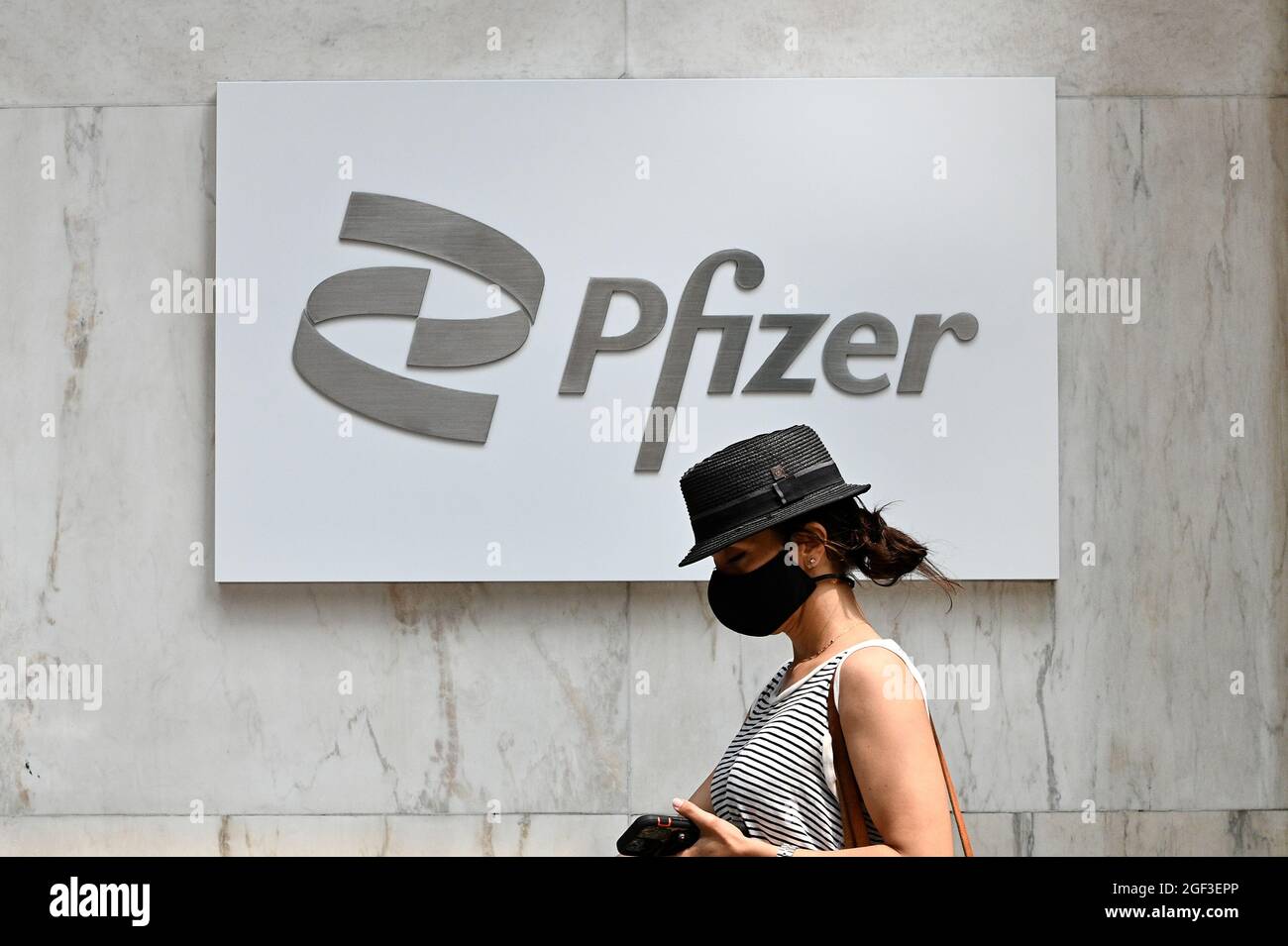 New York, États-Unis. 20 juillet 2021. Une femme passe devant le nouveau logo Pfizer à l'extérieur du siège de la société pharmaceutique Pfizer Inc., sur la 42e rue à New York, NY, le 20 juillet 2021. Pfizer a déclaré qu'elle s'attendait à ce que la Food and Drug Administration (FDA) approuve entièrement son vaccin COVID-19 au début de janvier 2022; le vaccin Pfizer-BioNTech COVID-19 est utilisé sous autorisation d'utilisation d'urgence. (Photo par Anthony Behar/Sipa USA) crédit: SIPA USA/Alay Live News Banque D'Images