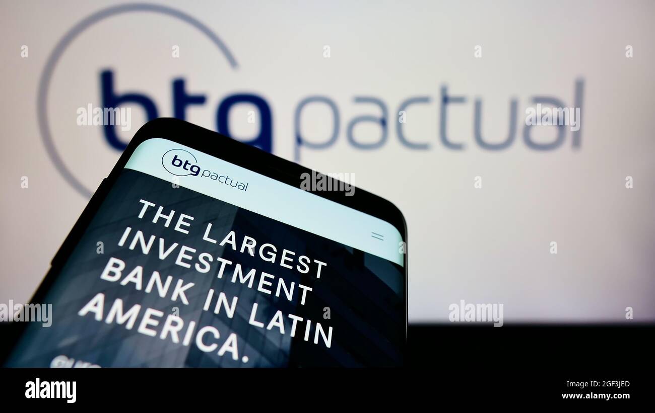 Smartphone avec le site Web de la société financière brésilienne BTG Penal S.A. à l'écran devant le logo de l'entreprise. Faites la mise au point dans le coin supérieur gauche de l'écran du téléphone. Banque D'Images