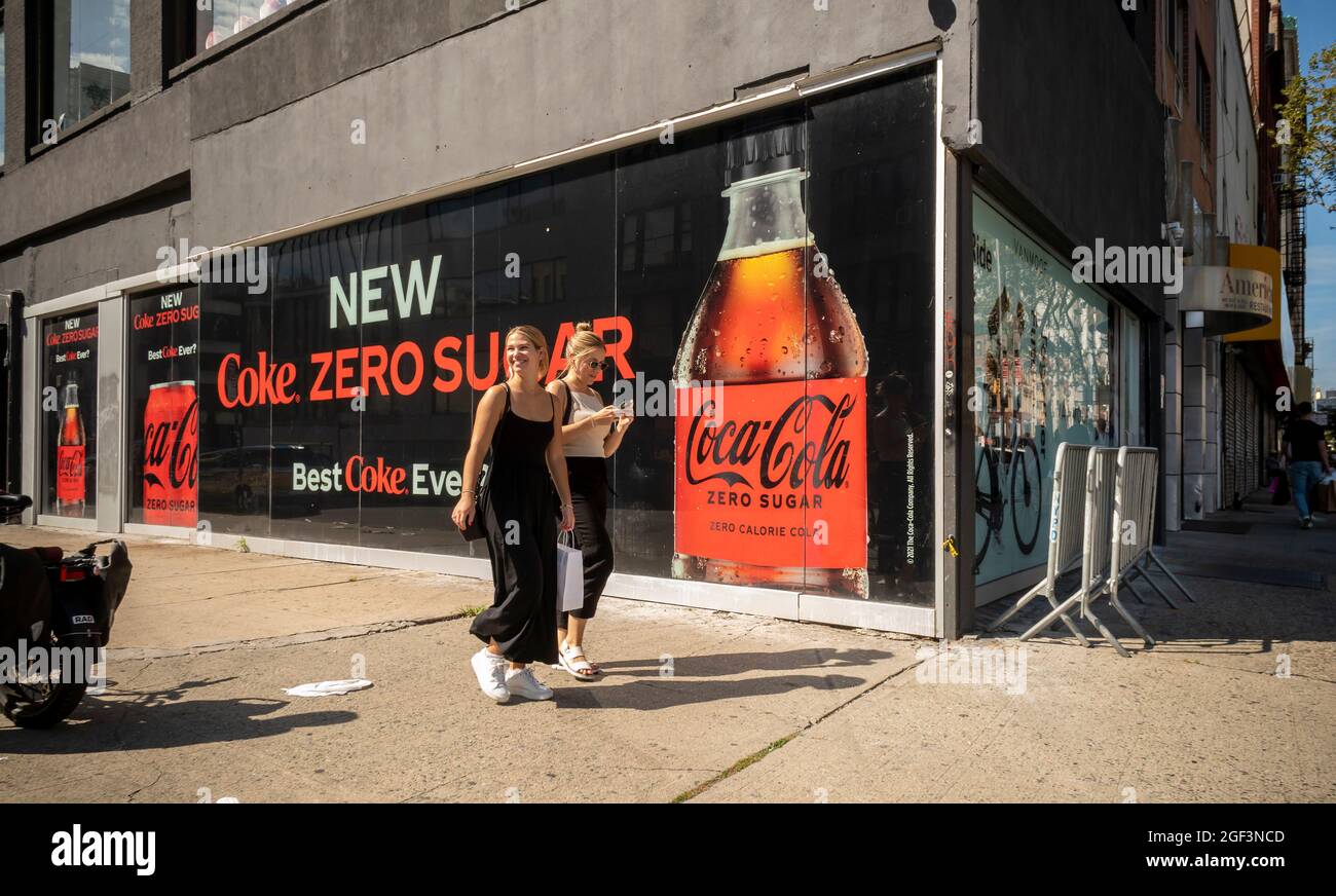 Les femmes marchent devant un panneau publicitaire le nouveau Coke Zero Sugar à New York le dimanche 15 août 2021. (© Richard B. Levine) Banque D'Images