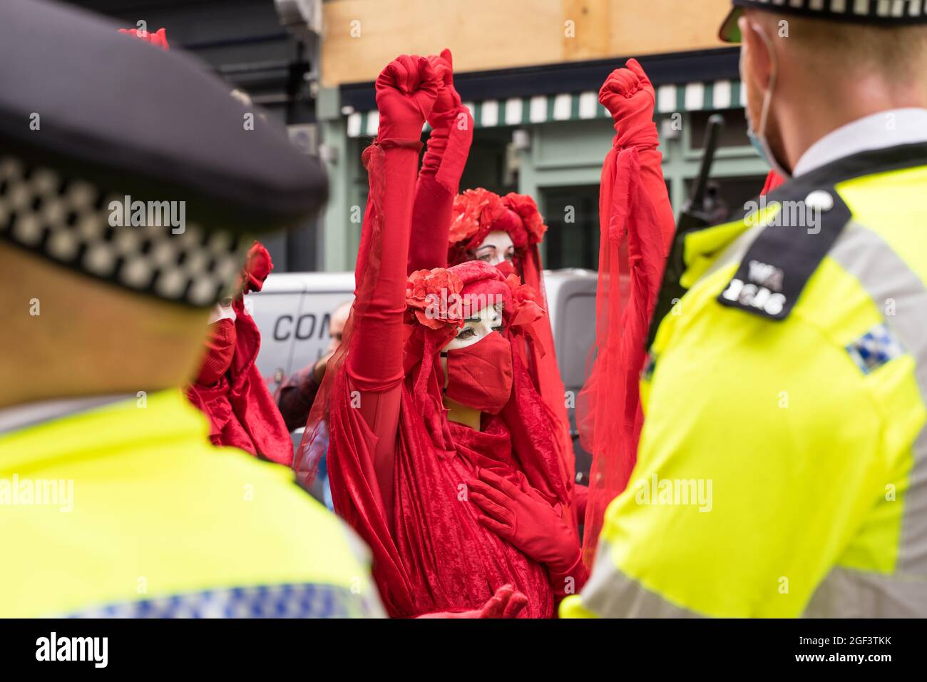 Extinction rébellion protestation contre le changement climatique. Femmes en costumes rouges entourées par la police. Londres - 23 août 2021 Banque D'Images