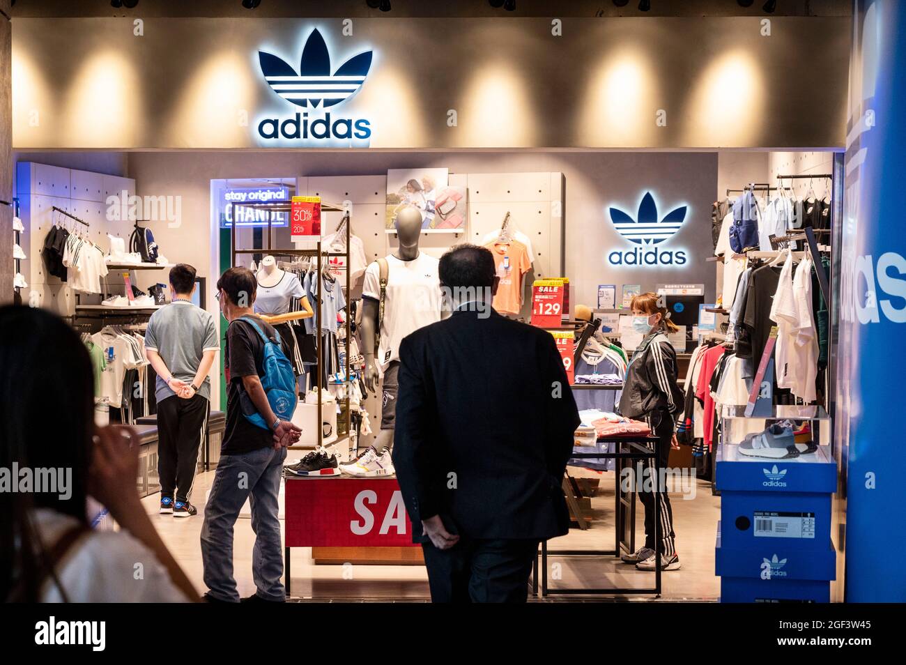Les acheteurs sont vus dans le magasin Adidas de la marque multinationale allemande de vêtements de sport à Hong Kong. Banque D'Images