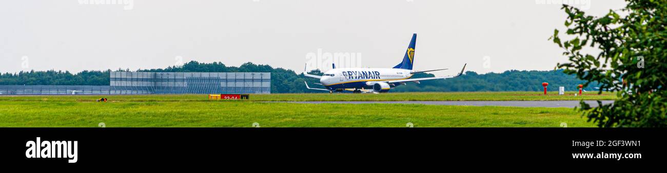 Ryan Air Ryanair Boeing 737 800 avion décollage de l'aéroport de Stansted Essex Angleterre avec le hangar d'entretien en arrière-plan bleu ciel jour Banque D'Images