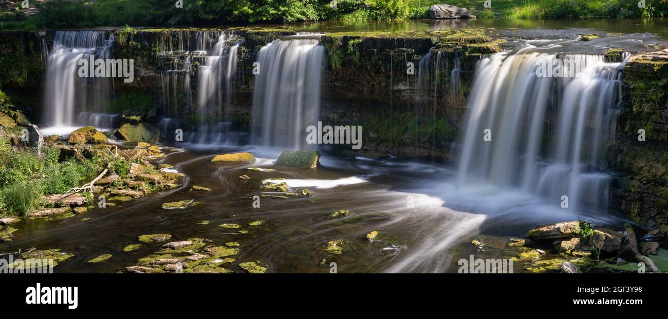 Un paysage de rivière idyllique dans la forêt avec une cascade Banque D'Images