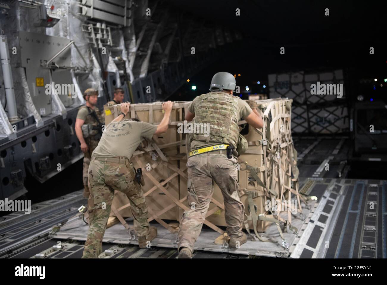 Les responsables de la Force aérienne des États-Unis et le personnel du Groupe d'intervention en cas de conflit déchargent du fret d'un avion C-17 Globemaster III de la Force aérienne des États-Unis à l'appui du refuge de l'opération alliés à l'aéroport international Hamid Karzaï (HKIA), en Afghanistan, le 22 août 2021. (É.-U. Photo de la Force aérienne par MSgt. Donald R. Allen) Banque D'Images