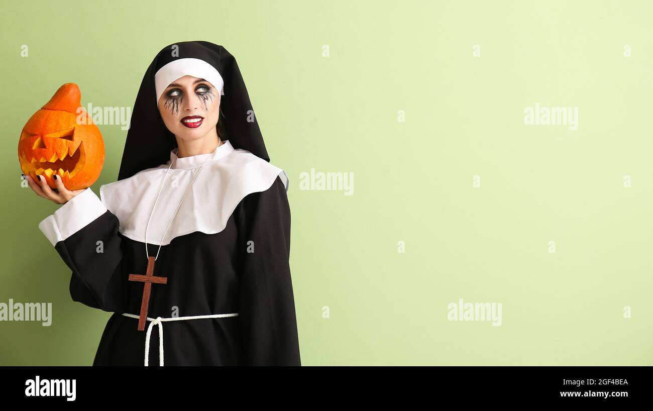 Femme habillée pour Halloween comme nonne avec la citrouille sur fond de  couleur Photo Stock - Alamy